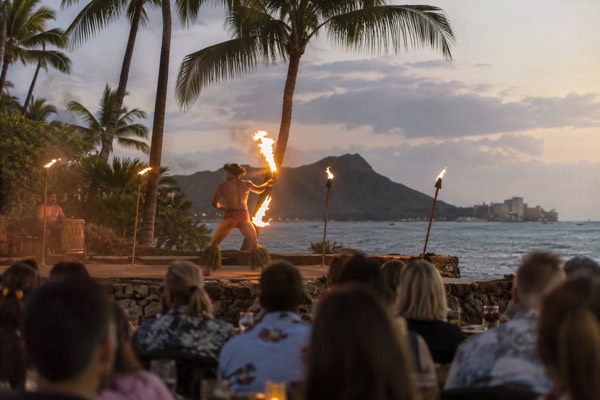 Fire-knife dancer performing at a luau after sunset