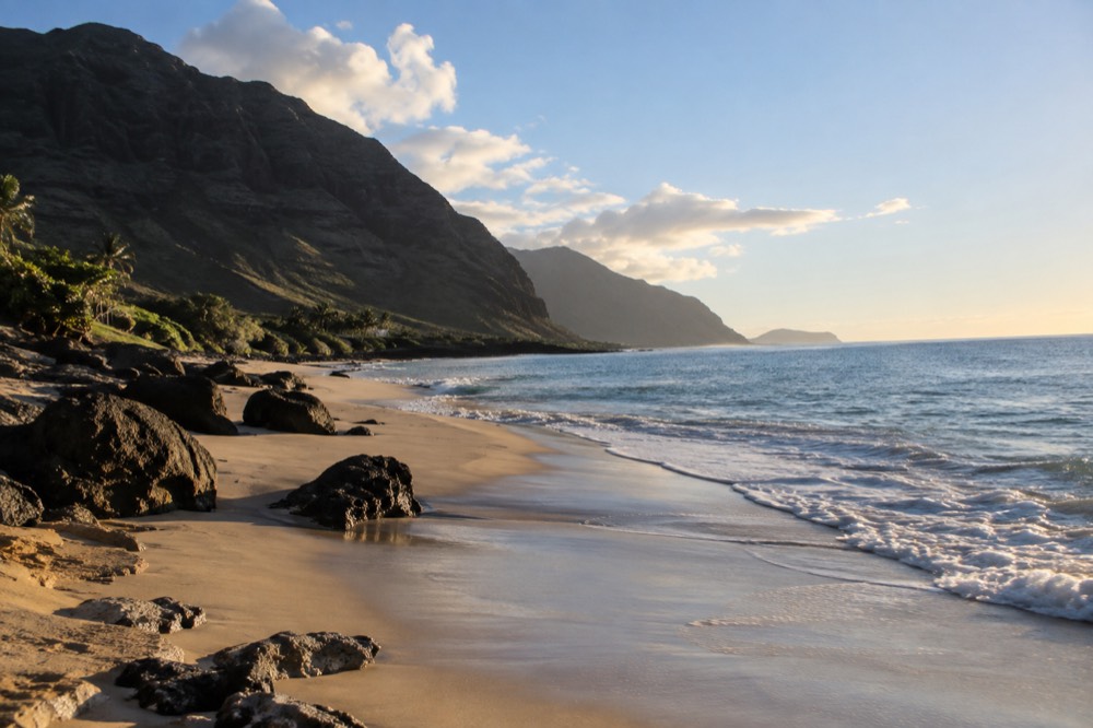 A quiet stretch of sand on Oahu's leeward coast with calm water and no people