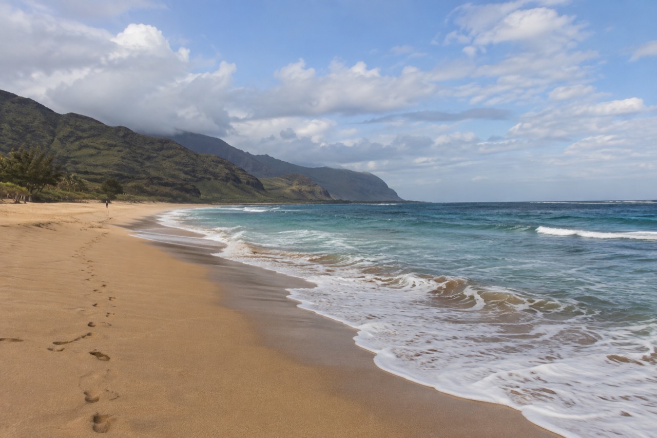 Empty golden beach on Oahu's leeward coast under a wide sky