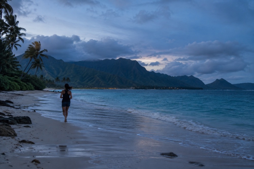 Turquoise water and palm trees along the windward coast of Oahu with green mountains behind the beach