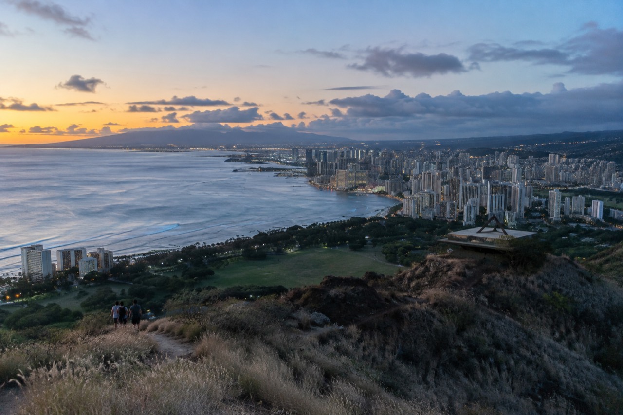 The Diamond Head crater rising above Waikiki beach and the Honolulu skyline at golden hour