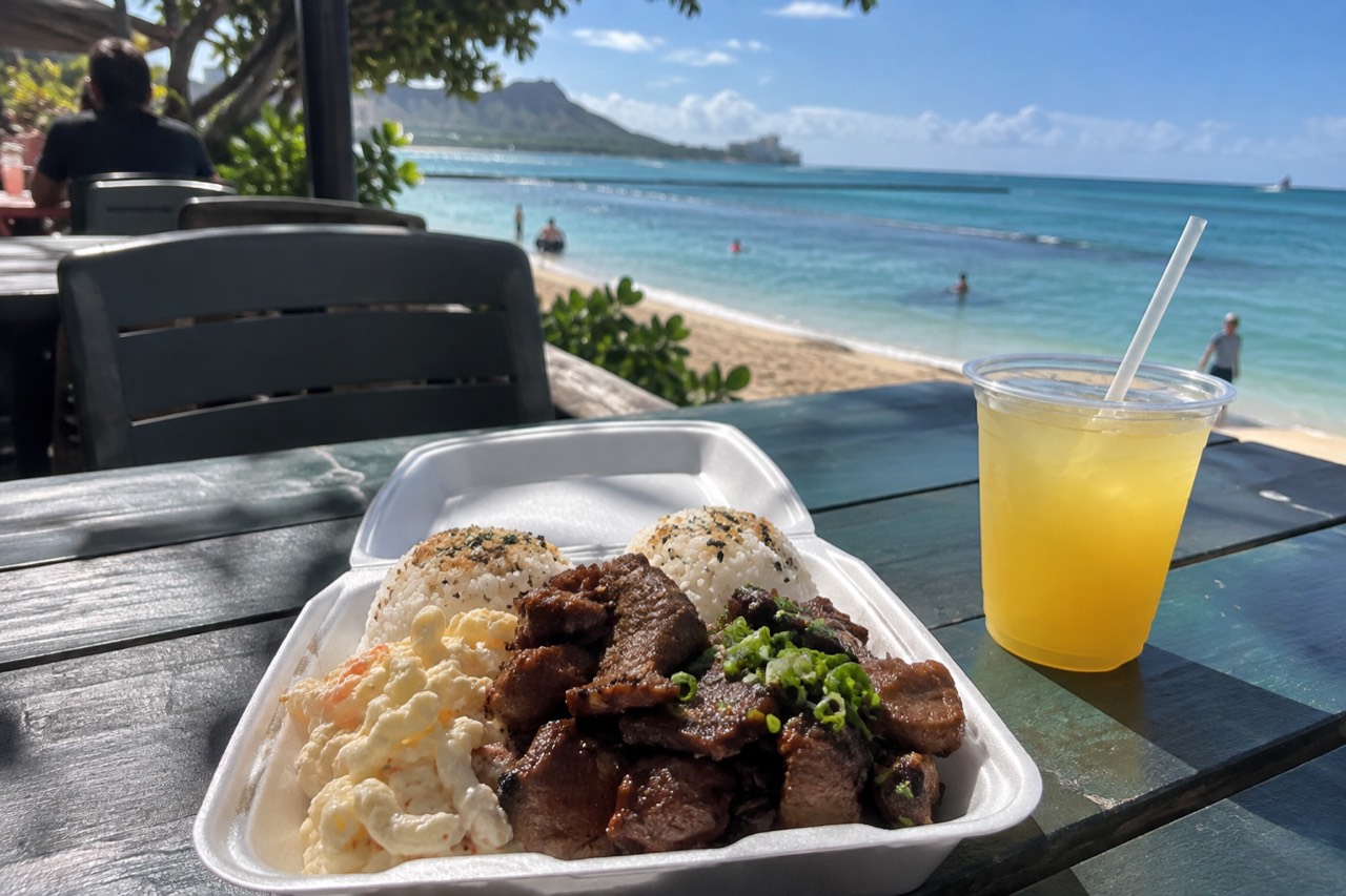A plate lunch with two scoops of rice and macaroni salad on a table at an open-air Oahu eatery