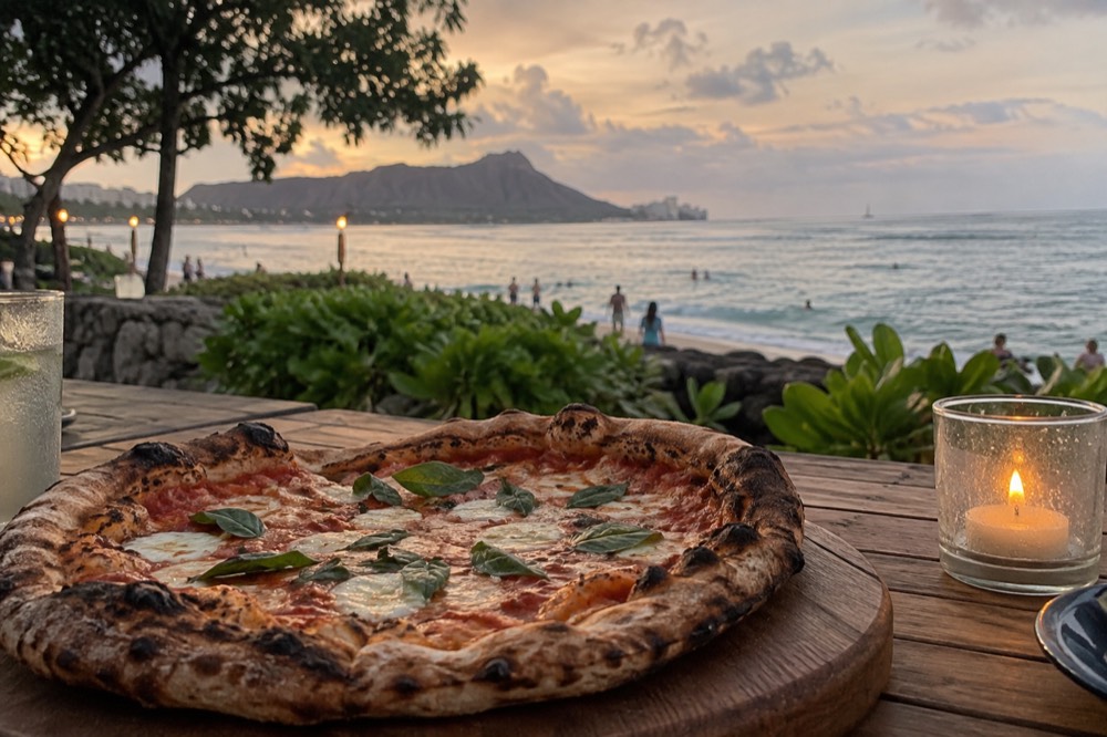 A pizza with charred crust resting on a wooden board at an outdoor table in the evening