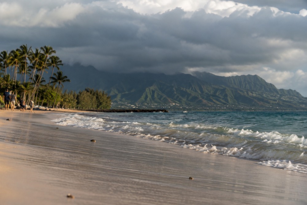 Dark rain clouds hanging over the green Koʻolau mountain ridges above a windward Oahu valley
