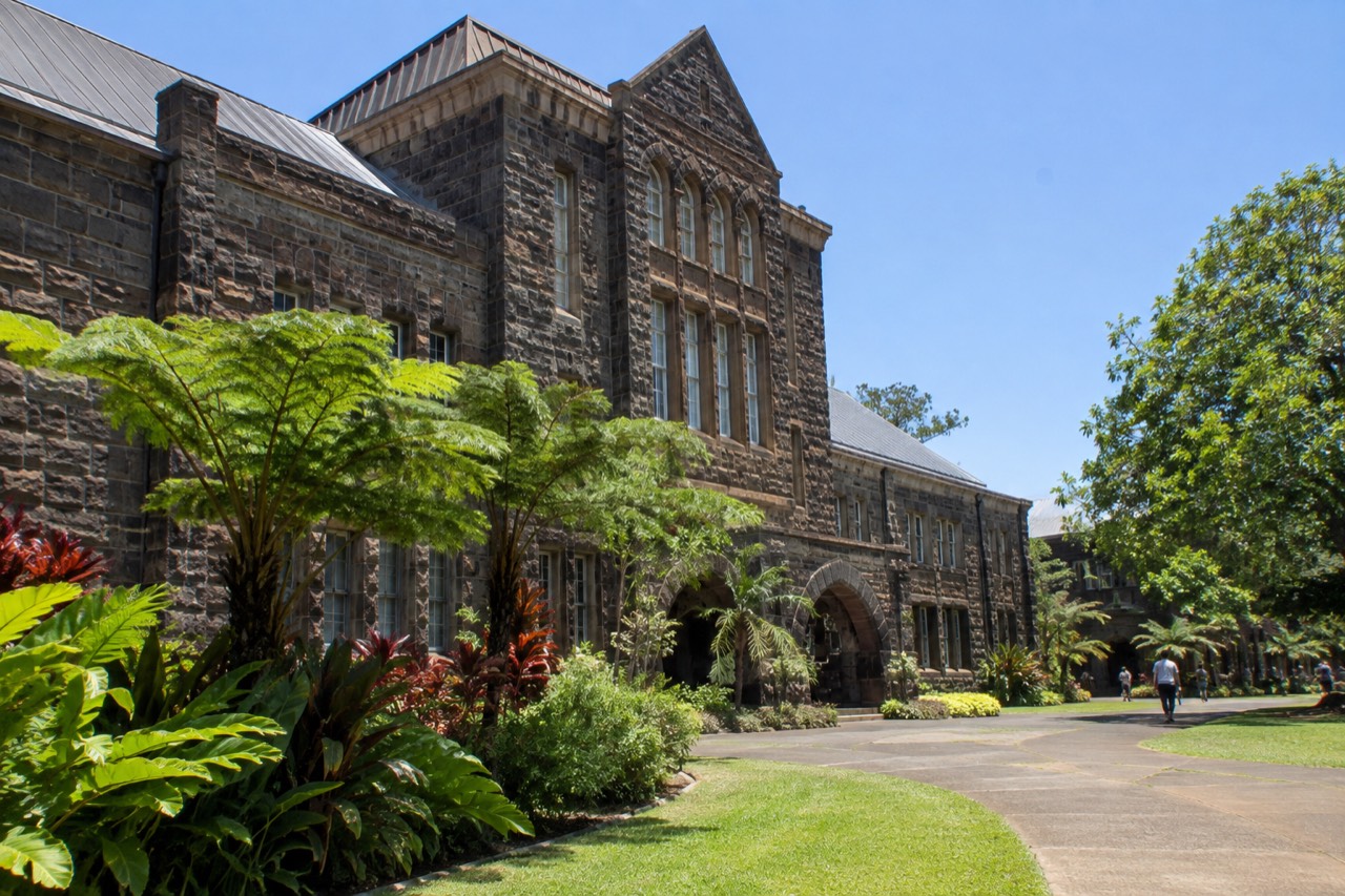 The historic stone exterior of the Bishop Museum under a clear Honolulu sky