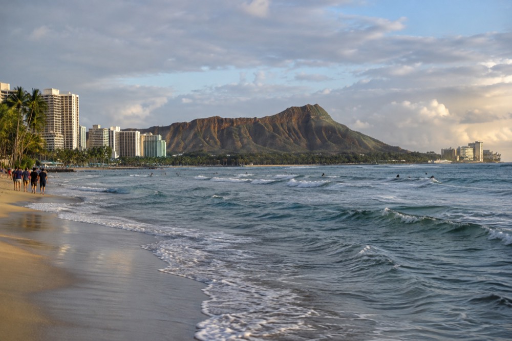 Diamond Head crater seen from Waikiki with the coastline curving toward the sunrise