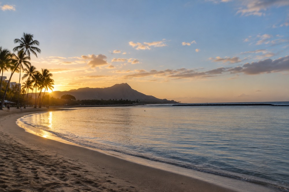 A quiet lagoon at golden hour with calm water and a distant ridgeline