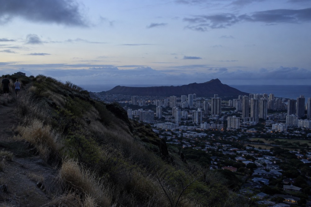 The Diamond Head crater rim rising above Waikiki rooftops under a morning sky